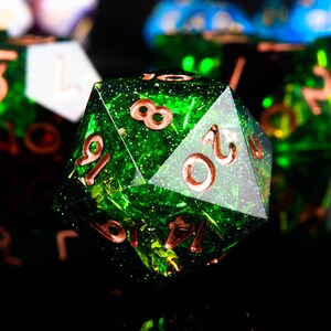 May include: A green, glittery, 20-sided dice with copper-coloured numbers. The dice is a popular tool for tabletop role-playing games.