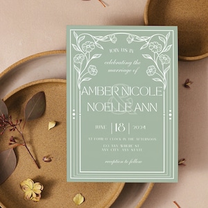 May include: A sage green wedding invitation with white floral illustrations and the text "You are invited to celebrate the marriage of Amber Nicole & Noel LeAnn June 18, 2024"