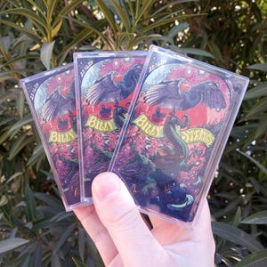 May include: Three cassette tapes with a colorful graphic design featuring a bird, a dragon, and the text "Billy Strings".