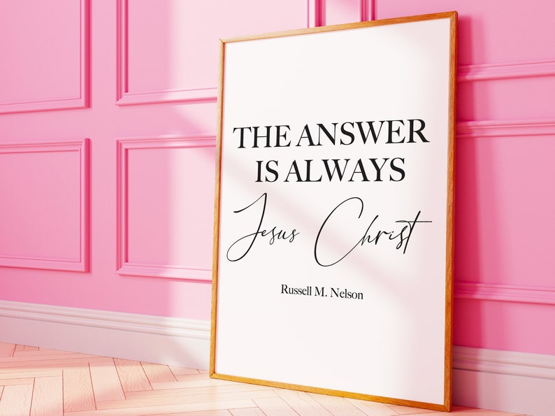 May include: A white framed print with a black quote that reads "The answer is always Jesus Christ" by Russell M. Nelson.