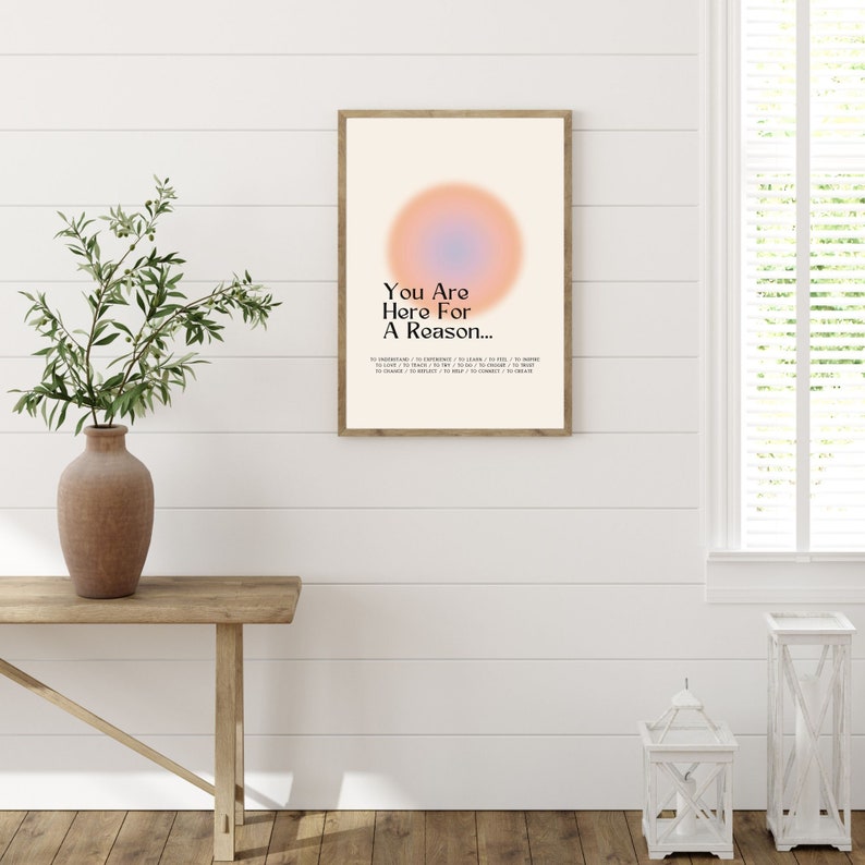 Op de afbeelding: Een ingelijst print met een perzik- en blauwe gradi&euml;ntcirkel en de tekst "You Are Here For A Reason..." in zwart. De tekst gaat verder met een lijst van redenen om hier te zijn, waaronder "to understand", "to experience", "to learn", "to love", "to teach", "to help", "to choose", "to create", "to believe", "to connect", "to change" en "to inspire".