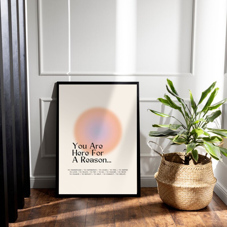 Op de afbeelding: Een motiverende poster met een wazige, pastelroze en blauwe cirkel in het midden. De tekst luidt "You Are Here For A Reason..." en somt een reeks werkwoorden op in twee kolommen.