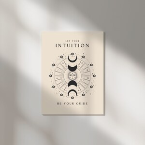 May include: A beige poster with a black and white illustration of a sun and moon with the text "Let your intuition be your guide".