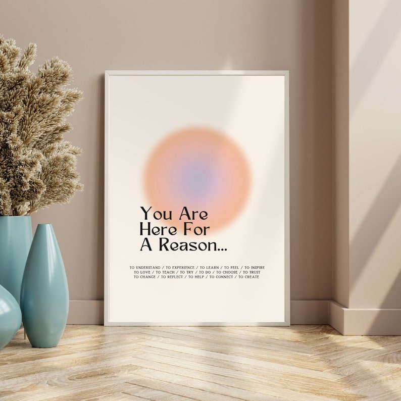 Op de afbeelding: Een motiverende poster met een licht oranje en blauwe gradi&euml;ntcirkel in het midden. De tekst luidt "You Are Here For A Reason..." en somt een reeks werkwoorden op: "To understand, to experience, to learn, to feel, to inspire, to love, to teach, to try, to do, to choose, to trust, to change, to reflect, to help, to connect, to create."