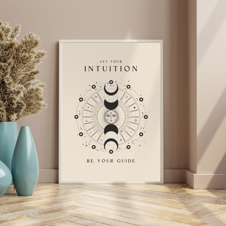 May include: A beige poster with a black and white illustration of a sun and moon with the text "Let your intuition be your guide".