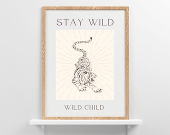 May include: A framed print with a beige background and a brown line drawing of a tiger. The text "STAY WILD" is at the top and "WILD CHILD" is at the bottom.
