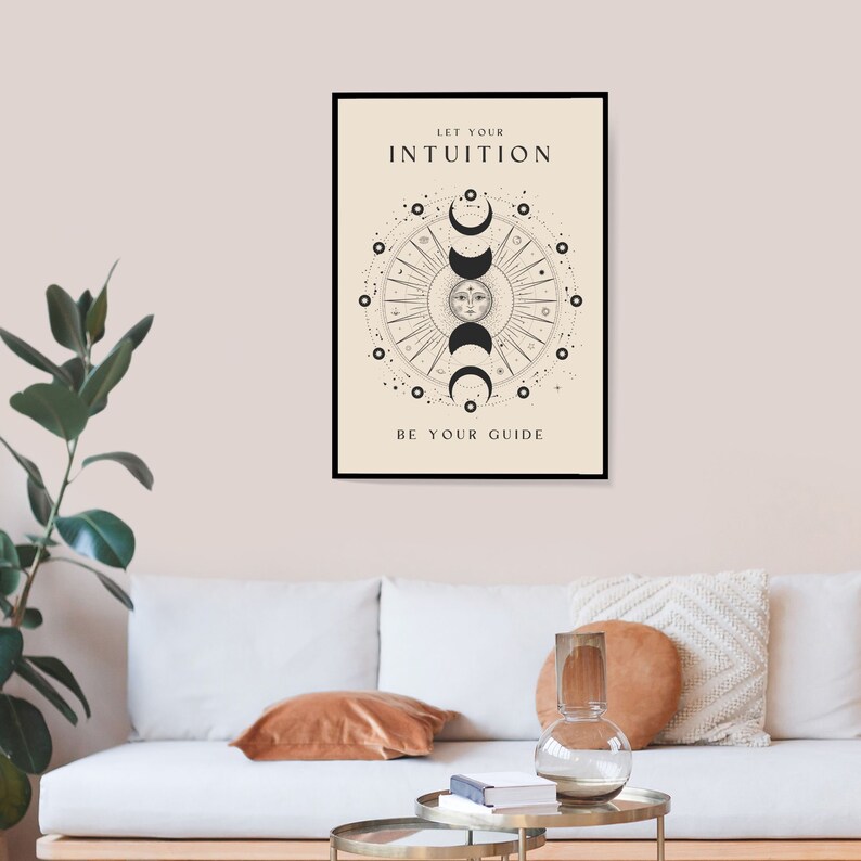 May include: A black and white poster with a circular design featuring a sun and moon phases. The text "Let your intuition be your guide" is printed on the poster.