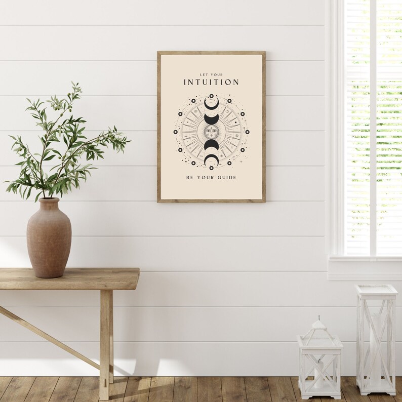 May include: A beige poster with a black and white illustration of a sun and moon with the text "Let your intuition be your guide".