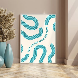 May include: A white framed print with a teal blue abstract design and the text "Just Going With The Flow".