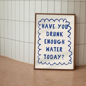 May include: A framed print with a white background and blue text that reads "Have you drunk enough water today?" The text is surrounded by a blue wavy border.