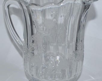 Jarra de cristal vintage grabada con margaritas florales y base de pedestal con borde festoneado.