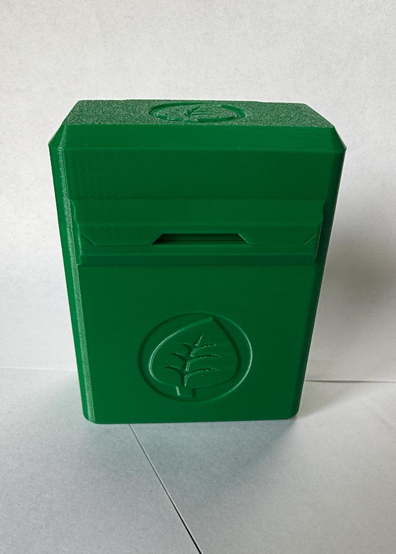 May include: A bright green, rectangular box with a leaf logo. The box has a slot on the front and a leaf design on the top. The box is made of a solid, matte material.