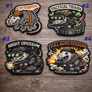 May include: Four embroidered patches depicting cartoon opossums in military-themed designs. The patches feature text such as "Stay Strapped," "Tactical Trash," "Night Opossum," and "Full Auto Opossum." Each patch is intricately stitched with a range of colours.