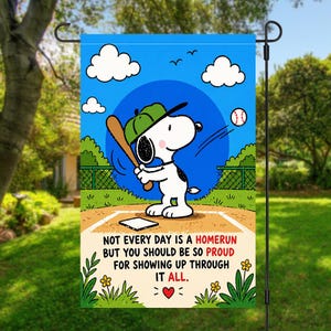 Könnte beinhalten: Eine Gartenflagge mit Snoopy beim Baseballspielen, mit grüner Kappe und Schläger. Die Flagge hat einen blauen Himmel mit Wolken und den Text: "NOT EVERY DAY IS A HOMERUN BUT YOU SHOULD BE SO PROUD FOR SHOWING UP THROUGH IT ALL."