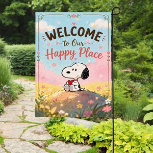 Może przedstawiać: Flaga ogrodowa ze Snoopy trzymającym czerwone serce, z napisem "WELCOME to Our Happy Place". Tło to niebo z chmurami i kwiatami, umieszczone w ogrodzie.