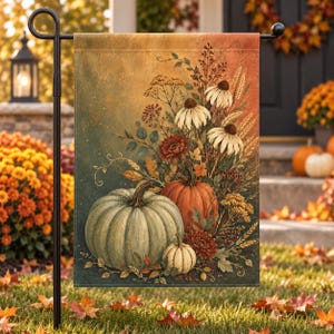 May include: A rectangular garden flag featuring a seasonal autumn illustration of a large pale green pumpkin, a medium orange pumpkin, and a small white pumpkin surrounded by white coneflowers, wheat stalks, and dark red flowers on a gradient background.