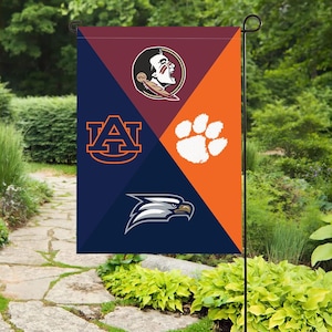 Puede incluir: Una bandera de jardín con cuatro secciones con logotipos de equipos universitarios. La parte superior izquierda es granate y tiene un logotipo de Seminole. La parte superior derecha es naranja con una huella de pata. La parte inferior izquierda es azul marino con un logotipo de Auburn. La parte inferior derecha es azul marino con un logotipo de águila.
