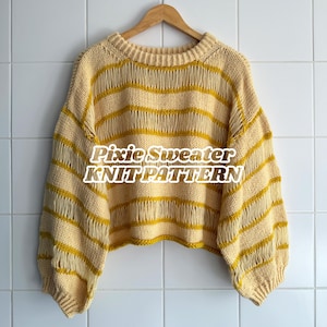 Puede incluir: Un suéter de punto color crema con rayas horizontales amarillas. El suéter tiene un corte holgado, mangas largas y cuello redondo. El texto "Pixie Sweater KNIT PATTERN" se muestra en la parte delantera del suéter.