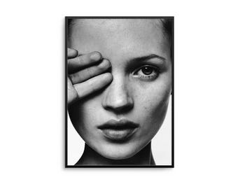 Op de afbeelding: Zwart-wit portret in een lijst van een persoon met de hand voor een oog. De afbeelding is een close-up van het gezicht, met de nadruk op het oog en de gelaatstrekken. Het portret zit in een rechthoekige lijst.