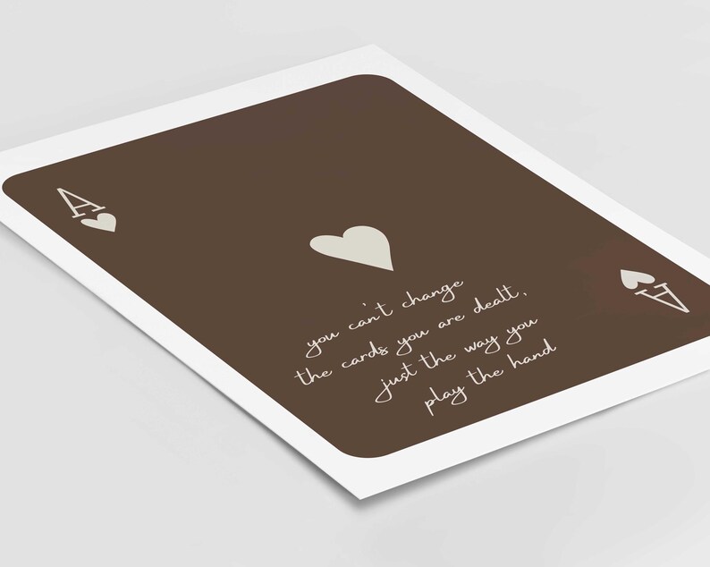 May include: A brown playing card print featuring the Ace of Hearts. The card has a white border and includes the text: "you can't change the cards you are dealt, just the way you play the hand."