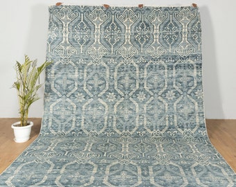 Könnte beinhalten: Ein blauer und weißer Teppich mit geometrischem Muster. Der Teppich hat einen Fransenrand und ist aus einem weichen, gewebten Material gefertigt.