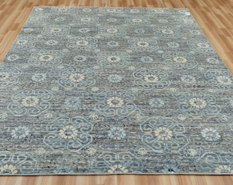 Könnte beinhalten: Ein rechteckiger Teppich mit einem floralen Muster in Grau-, Blau- und Cremetönen. Der Teppich hat einen Used-Look, einen niedrigen Flor und eine weiche Textur. Das florale Design wiederholt sich über die gesamte Oberfläche des Teppichs.