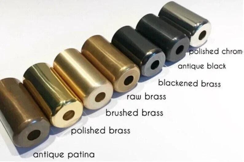 May include: Close-up of eight metal cylinder caps in different finishes: polished chrome, antique black, blackened brass, raw brass, brushed brass, polished brass, antique patina.