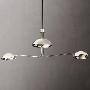 May include: A chrome three-light pendant light fixture with three dome-shaped shades.