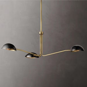 May include: A gold-toned three-light chandelier with black dome-shaped shades. The chandelier has a modern design with a simple, geometric shape.