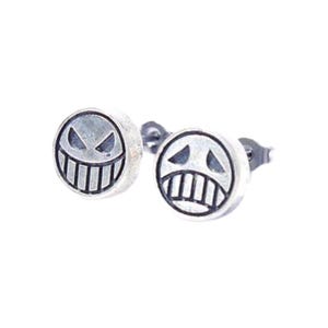 May include: A pair of silver-toned stud earrings. Each earring features a circular design with a stylized face, including a wide grin and angular eyes. The earrings are set against a white background.