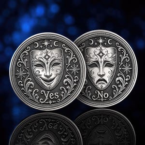 Può includere: Due monete circolari in metallo color argento con intricate incisioni in rilievo. Una mostra una maschera teatrale sorridente con la parola Yes, l'altra una maschera triste con la parola No, entrambe circondate da stelle e motivi a volute.