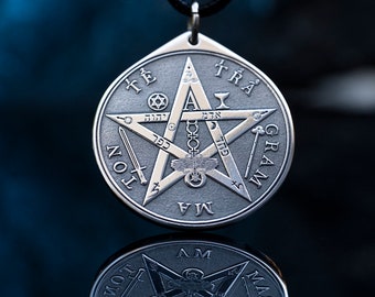 May include: A silver pendant with a five-pointed star, the words "TETRAGRAMMATON" and "TETRA GRAM", and Hebrew text. The pendant is hanging from a black cord.