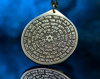 Puede incluir: Un colgante de plata con una estrella de David en el centro y texto hebreo alrededor. El colgante está colgado de una cadena de plata.