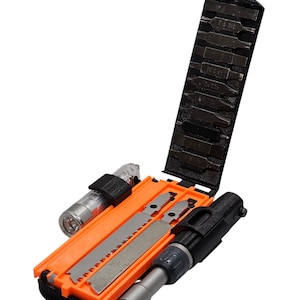 Puede incluir: Una multiherramienta con mango negro y detalles naranjas. Cuenta con una sierra, un destornillador con múltiples puntas y una linterna. La herramienta está abierta y las puntas del destornillador son visibles.