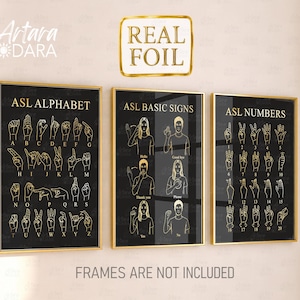 May include: Three black posters with gold foil lettering and illustrations. The first shows the ASL alphabet, the second displays ASL basic signs, and the third features ASL numbers. Each poster has gold text and outlines on a dark background.