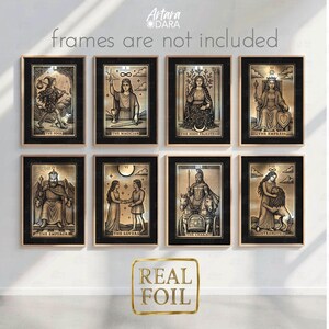 May include: Set of eight tarot card prints with gold foil accents, each framed in black. The cards feature detailed illustrations of The Fool, The Magician, The High Priestess, The Empress, The Emperor, The Lovers, The Chariot, and Strength.