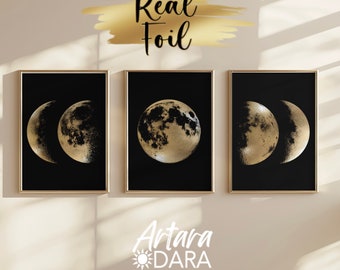 May include: Three black framed prints with gold foil moon phases on a black background. The prints read "Real Foil" at the top and "Artara Dara" at the bottom.