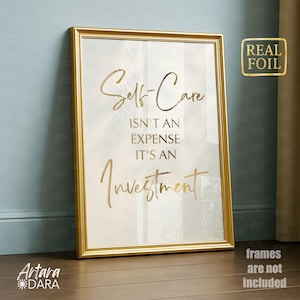 May include: A framed print with gold lettering that reads "Self-Care Isn't An Expense It's An Investment." The print has a gold frame and a "Real Foil" sticker. The bottom of the frame has the text "frames are not included."