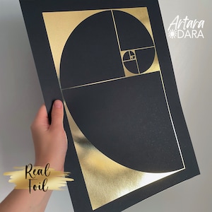 Peut inclure: Une impression noire et dorée avec un motif géométrique de cercles qui se chevauchent. L'impression présente le texte "Artara Dara" dans le coin supérieur droit et "Real Foil" dans le coin inférieur gauche.