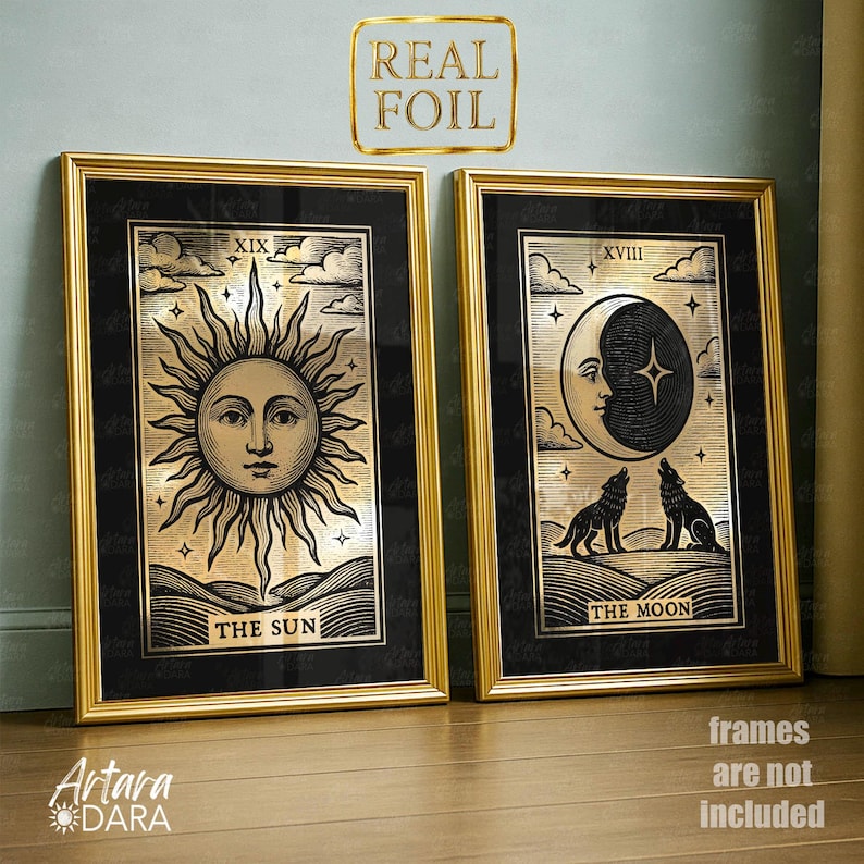 May include: Two framed tarot card prints. The left print features a sun with a face, the text "THE SUN", and the number "XIX". The right print shows a crescent moon with a face, two wolves, and the text "THE MOON" and the number "XVIII". Both prints have gold frames.