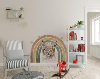 Puede incluir: Un adhesivo de pared que muestra un lince estilo acuarela guiñando un ojo, centrado frente a un arcoíris multicolor en tonos tierra apagados. El diseño incluye acentos circulares dispersos en tonos verdes y dorados como pieza decorativa.