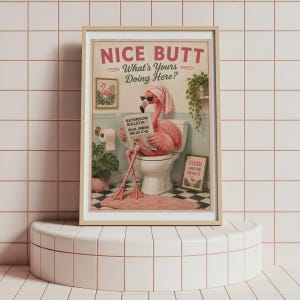 May include: A framed wall art print featuring a pink flamingo wearing a towel on its head and sunglasses while sitting on a toilet reading a newspaper. The text reads NICE BUTT What's Yours Doing Here? BATHROOM BULLETIN and FLUSH LIKE YOU MEAN IT.