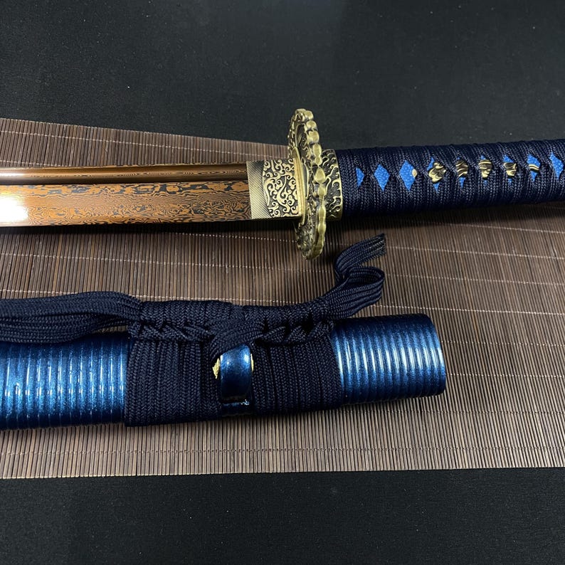 May include: A traditional Japanese katana sword with a brown and gold blade and a blue and black scabbard. The sword has a decorative gold handle with intricate designs.