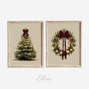 May include: Two framed prints featuring Christmas themes. One shows a decorated tree with a burgundy bow, the other a wreath with a burgundy bow. Both have warm white lights and are set against a neutral background.