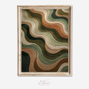 May include: A framed abstract art print featuring a textured design of flowing, wavy lines. The color palette includes shades of brown, green, and beige. The artwork is in a gold-colored frame. The artist's name, "Elkie Design Studio," is at the bottom.