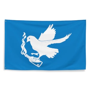 Könnte beinhalten: Eine blaue Flagge mit einer weißen Taube, die einen Molotowcocktail trägt. Die Taube ist im Flug dargestellt, mit ausgebreiteten Flügeln. Der Cocktail ist mit Flammen dargestellt. Die Flagge hat Ösen in den Ecken zum Aufhängen.