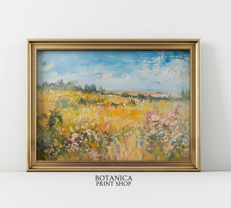 May include: A painting of a field of wildflowers in a gold frame. The field is a mix of yellow, green, and pink flowers. The sky is blue with white clouds. The painting is titled "BOTANICA PRINT SHOP".