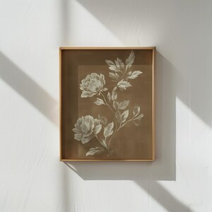 以下が含まれることがあります： セピア色の背景に白い牡丹の花と葉が描かれた、額装された植物画。薄い金色のフレームに収められており、クラシックでエレガントな雰囲気を醸し出しています。インテリアに最適です。