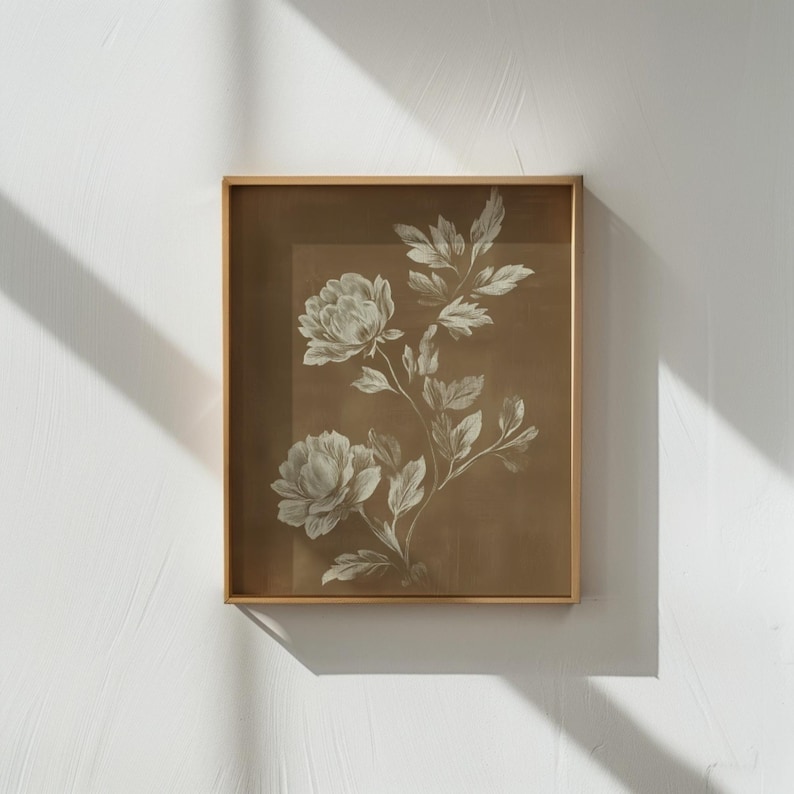 以下が含まれることがあります： セピア色の背景に白い牡丹の花と葉が描かれた、額装された植物画。薄い金色のフレームに収められており、クラシックでエレガントな雰囲気を醸し出しています。インテリアに最適です。