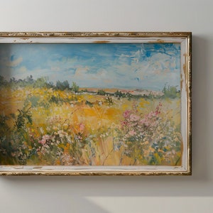 May include: A framed painting depicting a landscape with a field of wildflowers in shades of yellow, pink, and white. The sky is blue with white clouds. The painting is in a rustic, white-washed frame.